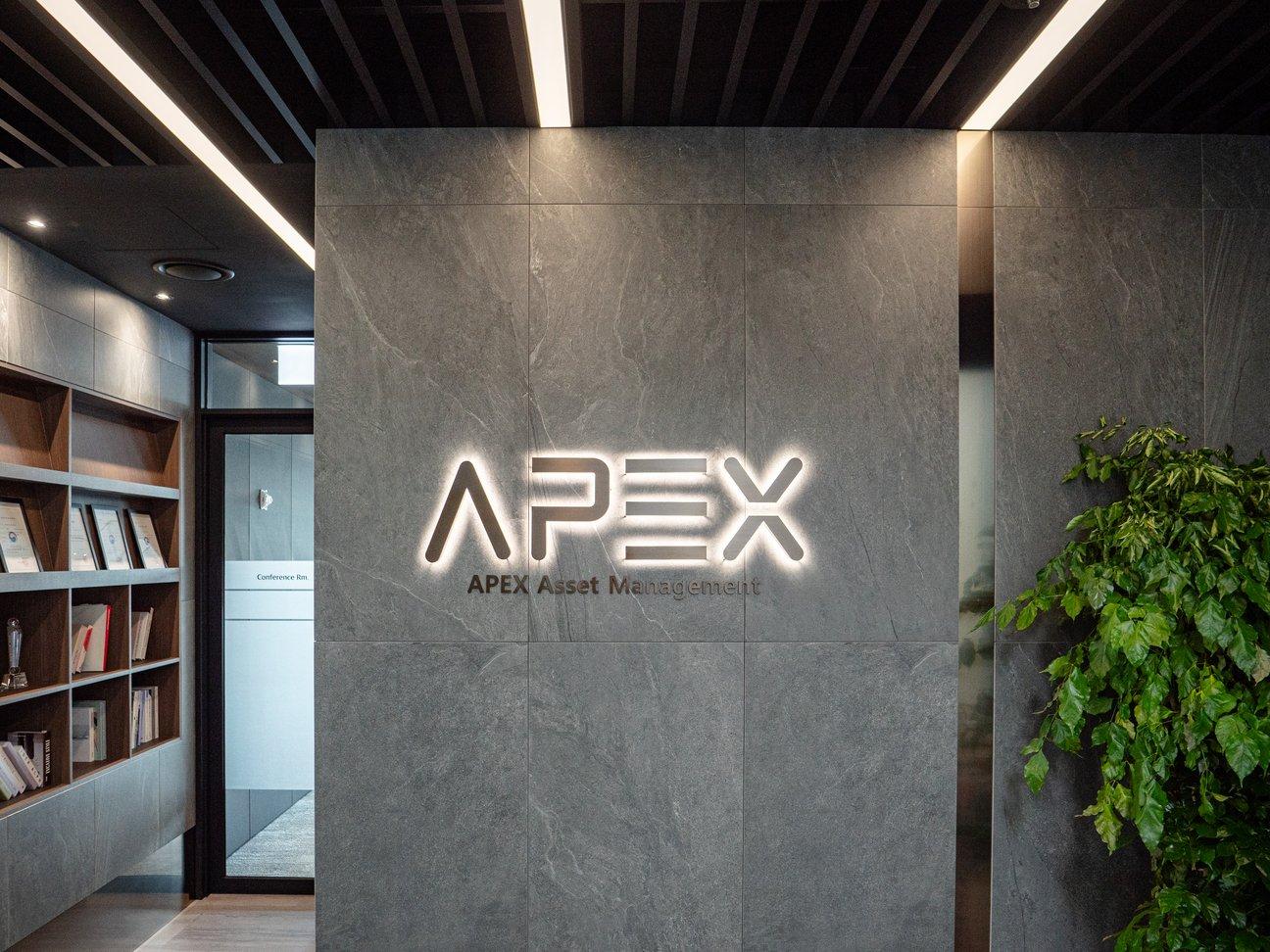TP타워 APEX Asset Management 오피스의 석재 벽과 조명 로고